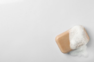Photo of Soap with fluffy foam on white background, top view