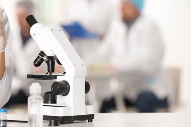 Photo of Modern microscope on table in laboratory, space for text. Research and analysis