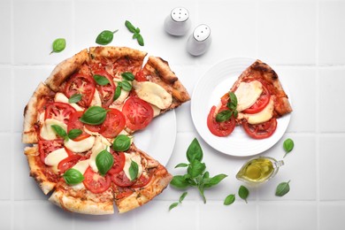 Photo of Delicious Caprese pizza on white tiled table, flat lay