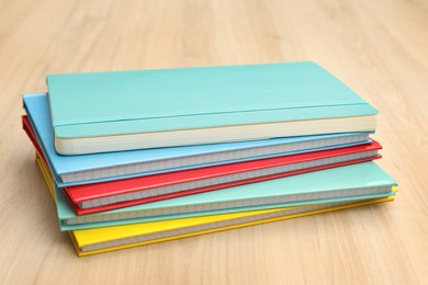 Photo of Stack of colorful planners on wooden table