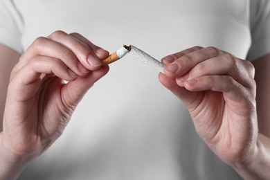 Photo of Stop smoking concept. Woman breaking cigarette, closeup