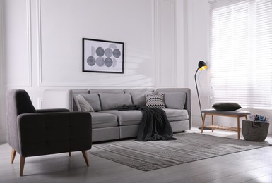 Photo of Cozy living room interior with comfortable grey sofa and armchair