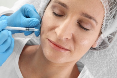 Photo of Woman getting facial injection in clinic. Cosmetic surgery concept
