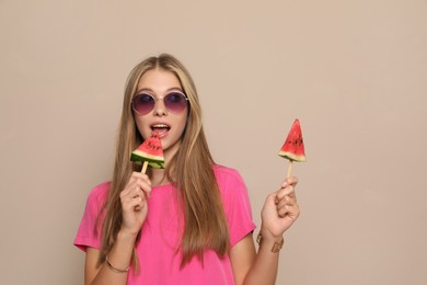 Photo of Beautiful girl with pieces of watermelon on beige background