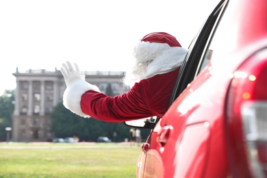 Photo of Authentic Santa Claus leaning out of car window, view from outside