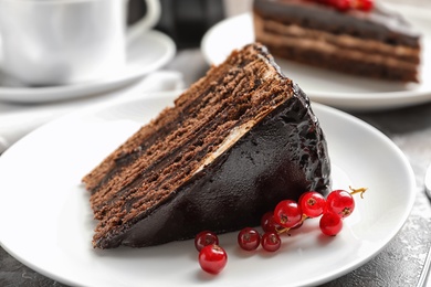 Photo of Plate with slice of chocolate cake and berries on table, closeup
