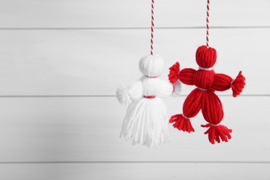 Photo of Traditional martisor shaped as man and woman on white background, space for text. Beginning of spring celebration