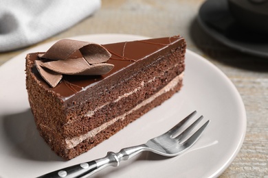 Photo of Delicious fresh chocolate cake served on wooden table, closeup