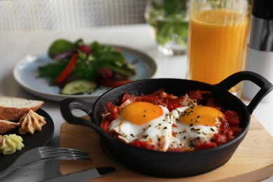 Photo of Tasty Shakshouka served on white table. Traditional Arabic dish