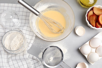 Dough and ingredients for cake on light grey table, flat lay