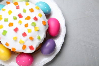 Photo of Beautiful Easter cake and painted eggs on light grey table, top view