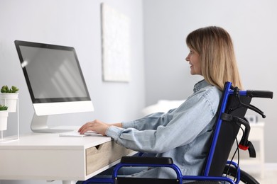 Photo of Woman in wheelchair using computer at home