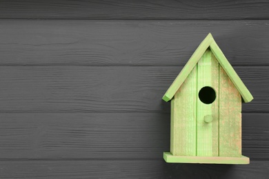 Photo of Beautiful bird house on grey wooden table, top view. Space for text