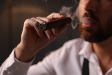 Photo of Bearded man smoking cigar indoors, closeup view