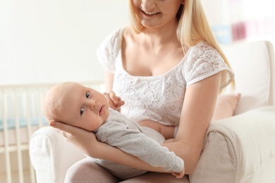 Photo of Happy mother with her baby sitting in armchair at home