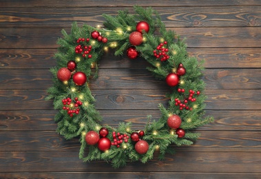 Photo of Beautiful Christmas wreath with festive decor on wooden background, top view