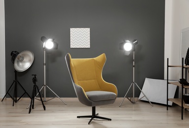 Interior of modern photo studio with armchair and professional equipment
