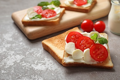 Tasty toast bread with cream cheese and cherry tomatoes on color background