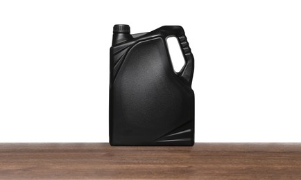 Photo of Motor oil in black container on wooden table against white background