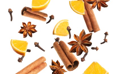 Image of Pieces of fresh orange, aromatic anise stars, cinnamon and cloves falling on white background