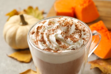 Photo of Delicious pumpkin latte with whipped cream on table, closeup