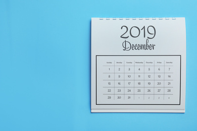 Photo of December 2019 calendar on light blue background, top view. Space for text