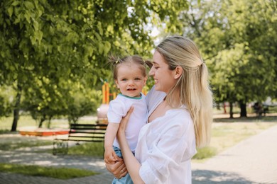 Photo of Happy mother with her daughter spending time together in park. Space for text