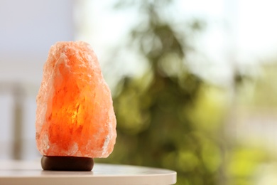 Photo of Himalayan salt lamp on table indoors, space for text