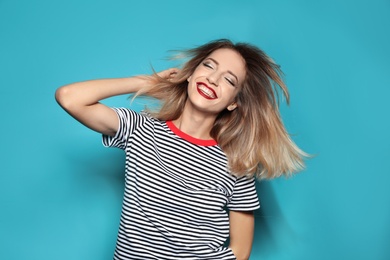 Photo of Beautiful young woman with healthy long blonde hair on color background