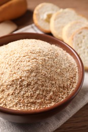 Photo of Fresh bread crumbs in bowl on table, closeup