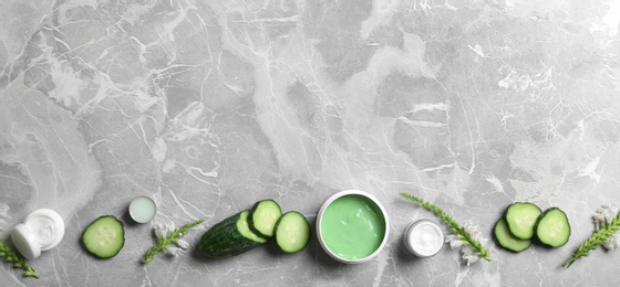 Photo of Flat lay composition with jars of body cream on grey marble background. Space for text