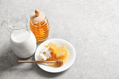 Photo of Beautiful composition with milk and honey on light background
