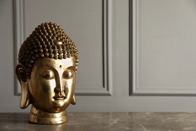 Photo of Buddha statue on grey table. Space for text