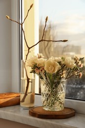 Photo of Beautiful spring flowers in vase on windowsill indoors