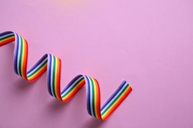 Bright rainbow ribbon on color background, top view with space for text. Symbol of gay community