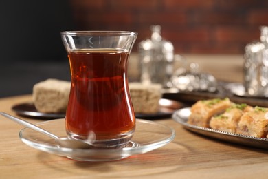 Traditional Turkish tea in glass on wooden table. Space for text