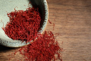 Photo of Aromatic saffron in bowl on table, top view. Space for text