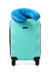 Photo of Soft travel pillow on turquoise suitcase isolated on white