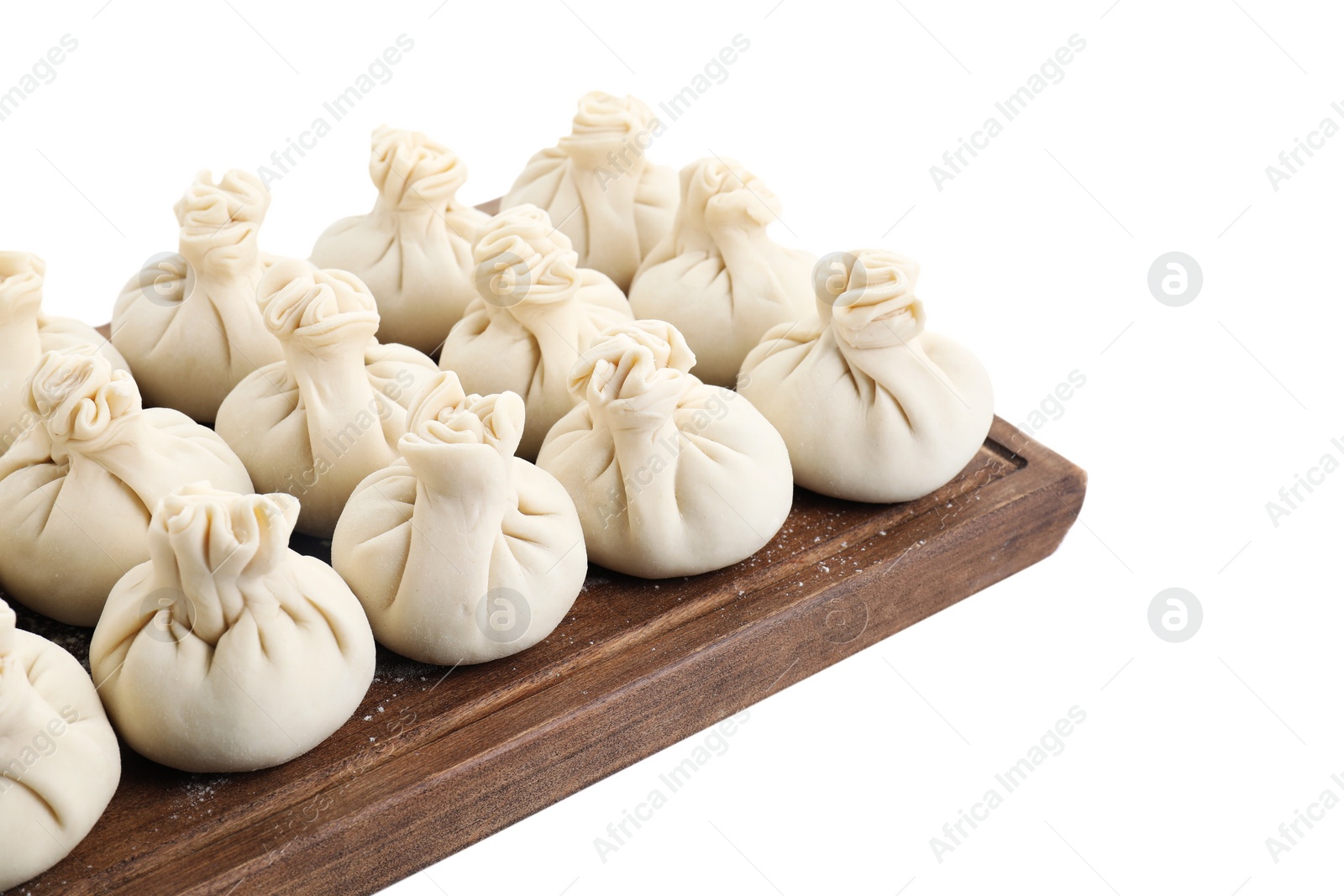 Photo of Wooden board with uncooked khinkali (dumplings) isolated on white. Georgian cuisine