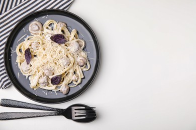Delicious pasta with mushrooms served on white table, flat lay. Space for text