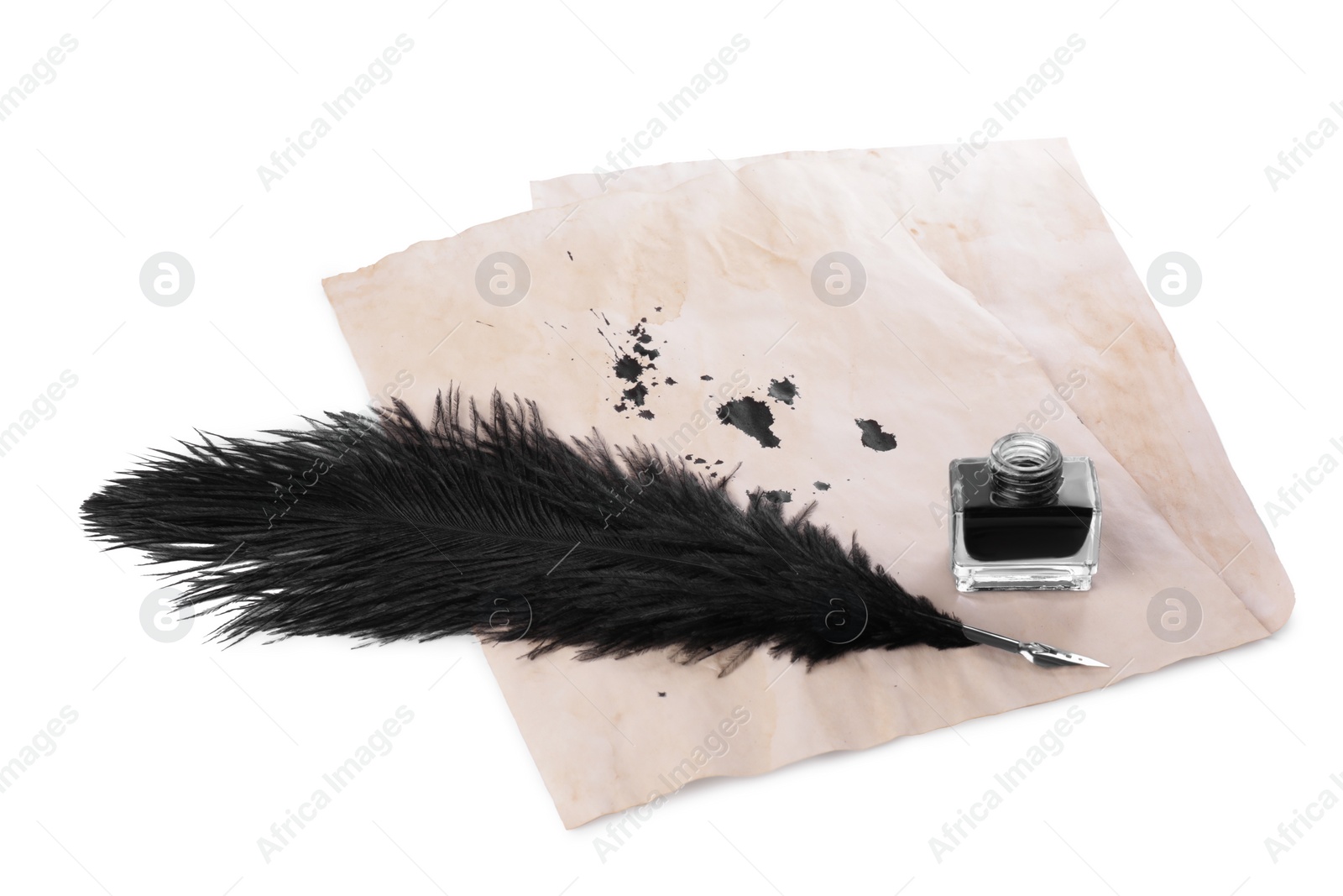 Photo of Parchment with stains of ink, feather pen and inkwell on white background