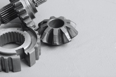 Photo of Different stainless steel gears on light grey background, closeup. Space for text