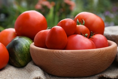 Photo of Many different ripe tomatoes on table outdoors, closeup