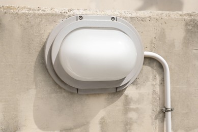 Modern electric street lamp on concrete wall