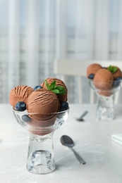 Photo of Glass bowl of chocolate ice cream served on light table, space for text
