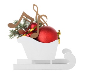 Photo of Decorative sleigh with wooden music notes and Christmas balls in sleigh isolated on white