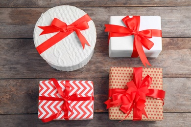 Different gift boxes on wooden background, flat lay