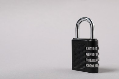 Photo of One steel combination padlock on grey background, closeup. Space for text