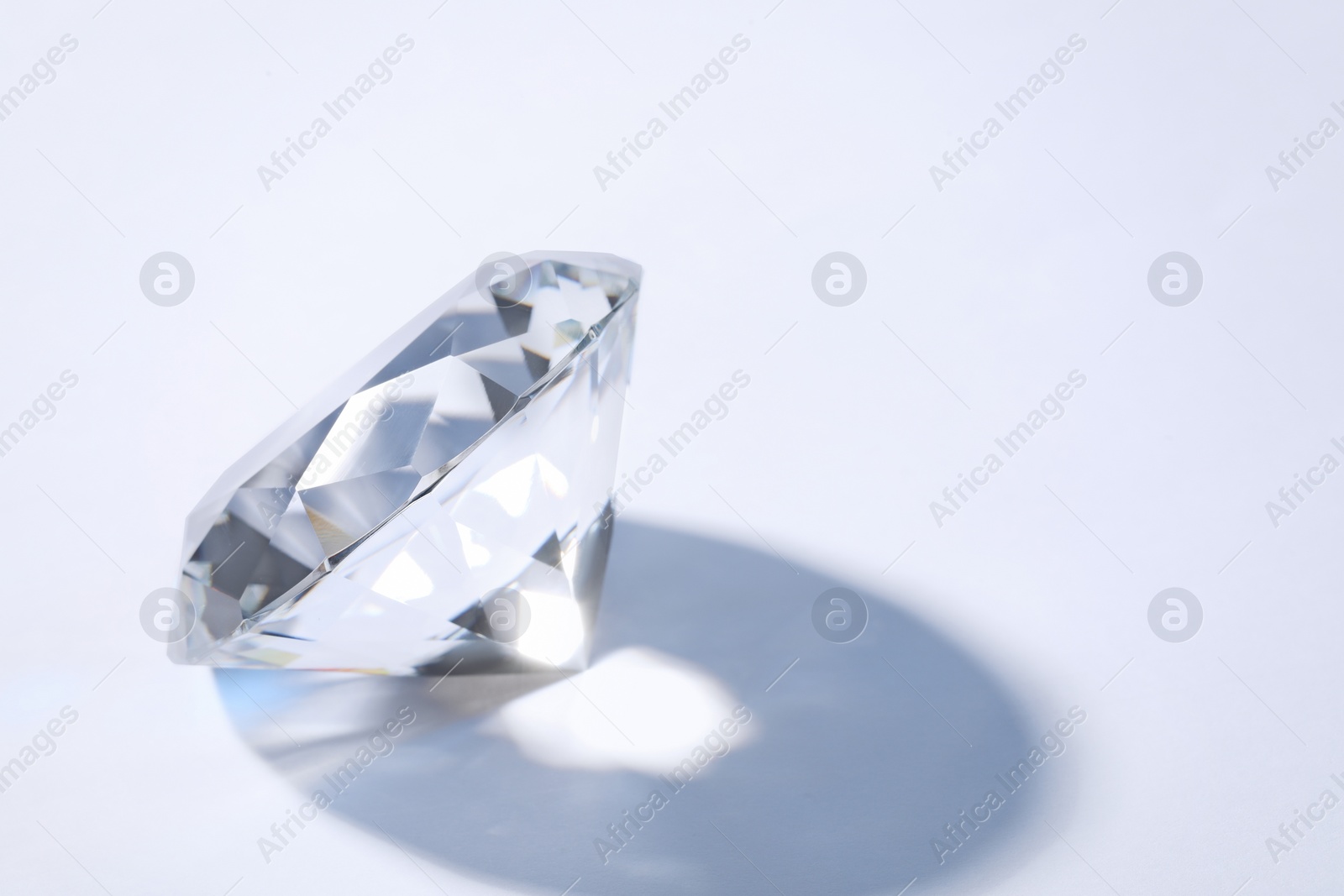 Photo of Beautiful dazzling diamond on white background, closeup. Space for text