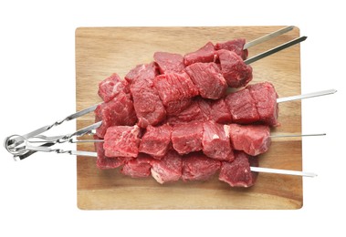 Metal skewers with raw meat on white background, top view